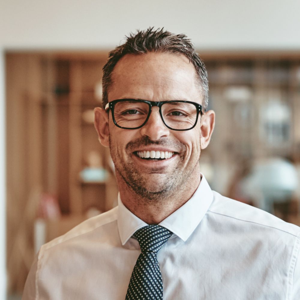smiling mature businessman standing alone in an of y89vgbd 1.jpg